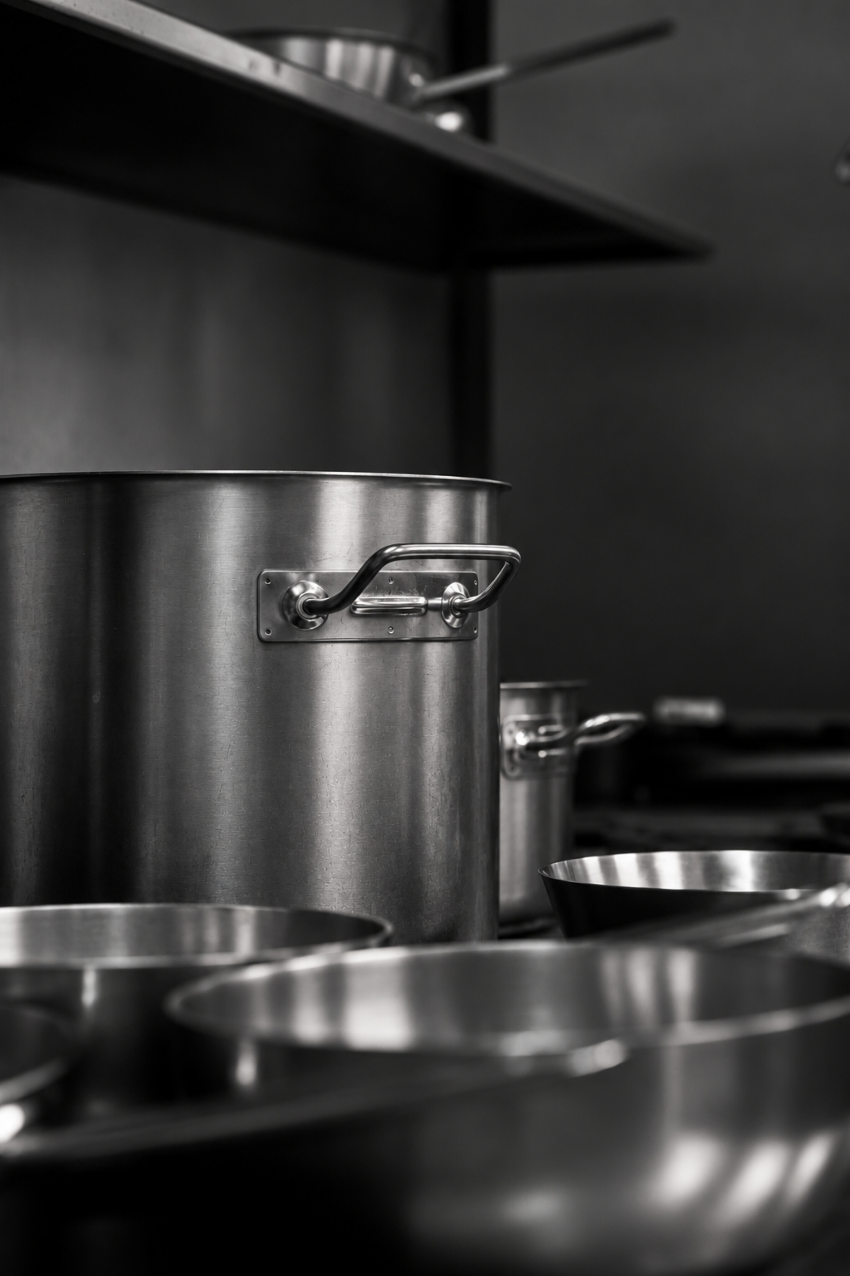 Monochrome stainless stockpots in a kitchen